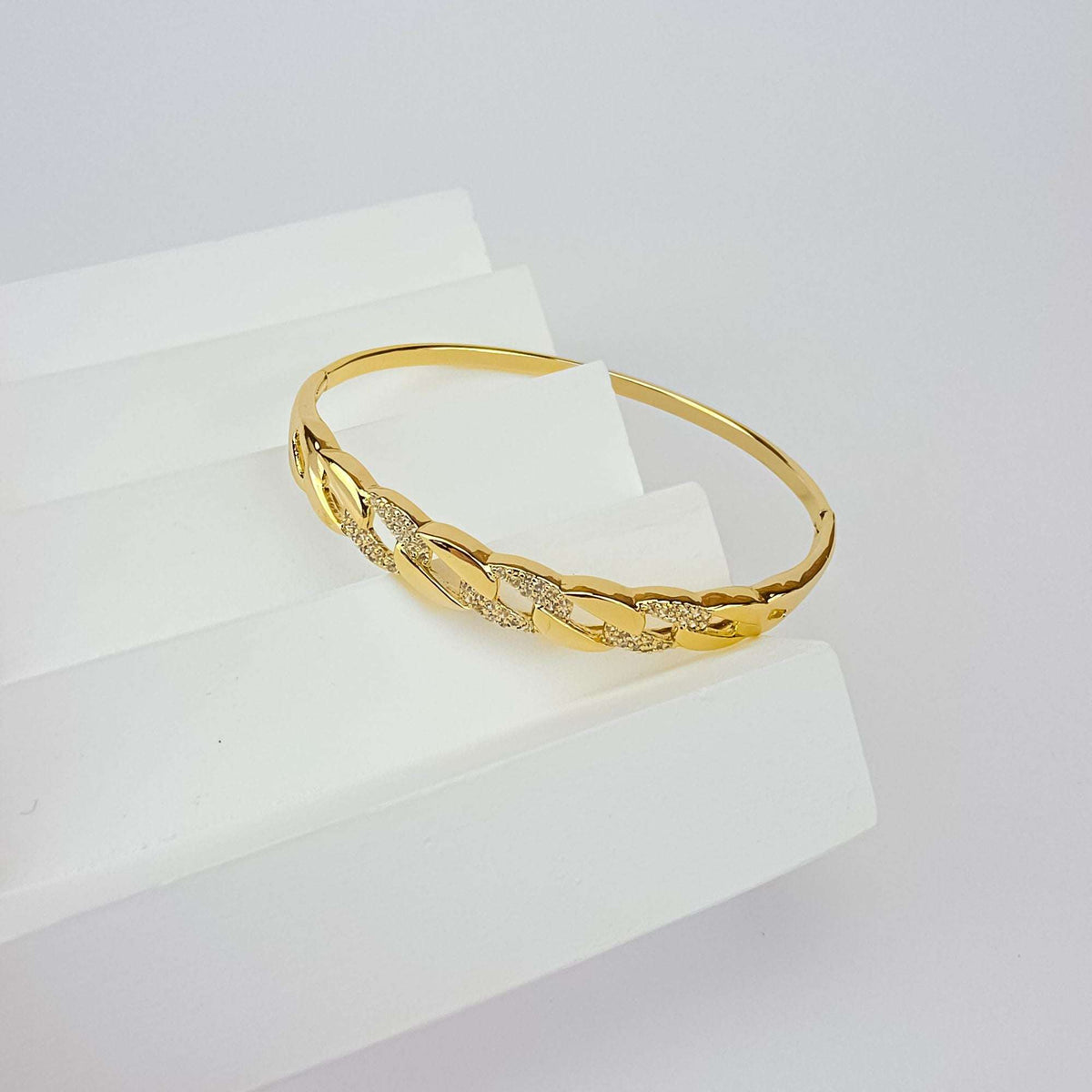 Kullatud jäik bangle käevõru ketilülide mustri ja sädelevate tsirkoonidega valgel alusel