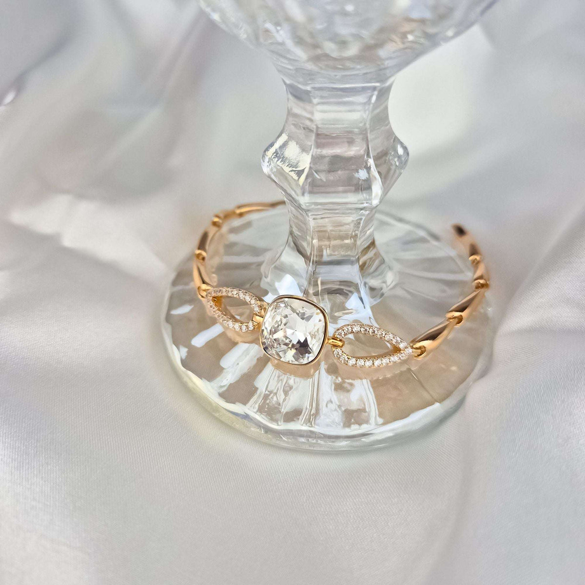 Käevõru sädeleva Swarovski kristalliga klaasalusel, näha tsirkoonidega kaunistatud lülid